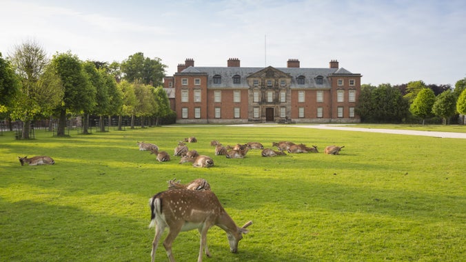 Dunham Massey historic house featuring grazing deer in the foreground.